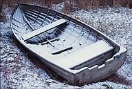 Snow-covered rowboat, lake Roxen